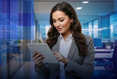 A business professional reviews information on a tablet in an office.