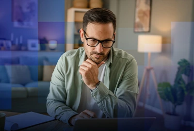 A man reviews paperwork at a desk beneath a blue geometric overlay.
