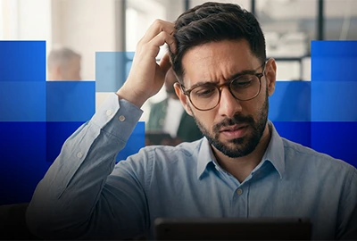 A concerned man looks at a tablet, with a blue geometric overlay.
