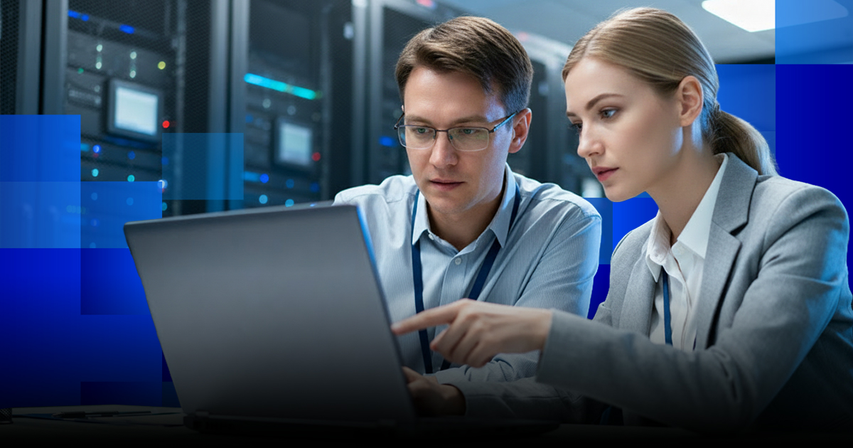 Two colleagues examining a laptop in a server room