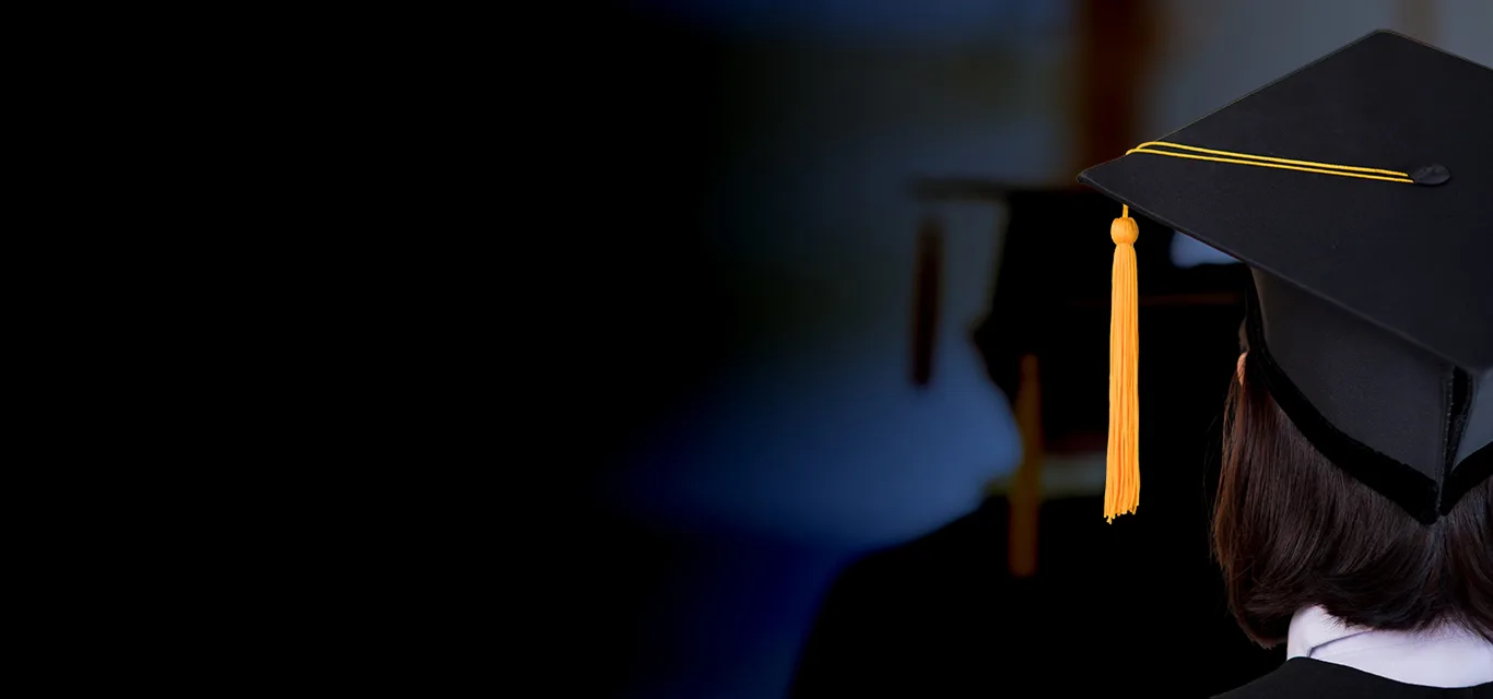 A graduate in a black mortarboard with a gold tassel, seen from behind.