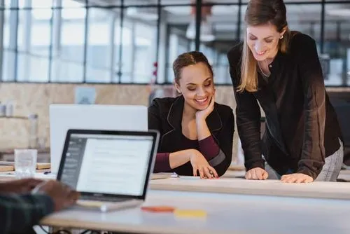 Colleagues reviewing a document at a desk.