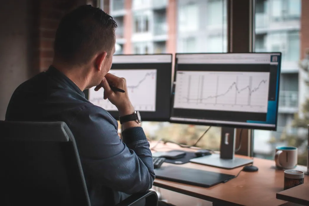 a young investor is reviewing a stock market graph on a computer monitor
